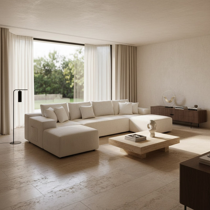maison velours white U-shaped modular velvet sectional sofa in a minimalist living room with travertine coffee table
